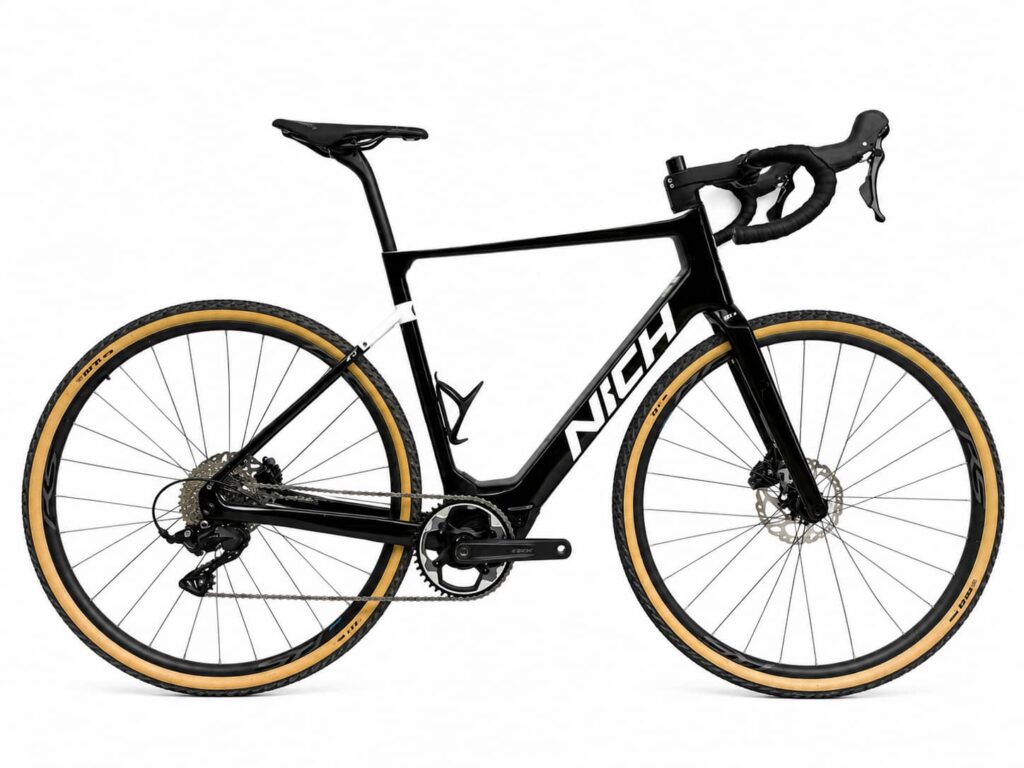 Studio photo of a black and white Nich carbon E-gravel bike, a premium hybrid bike choice for mixed-terrain cycling holidays.