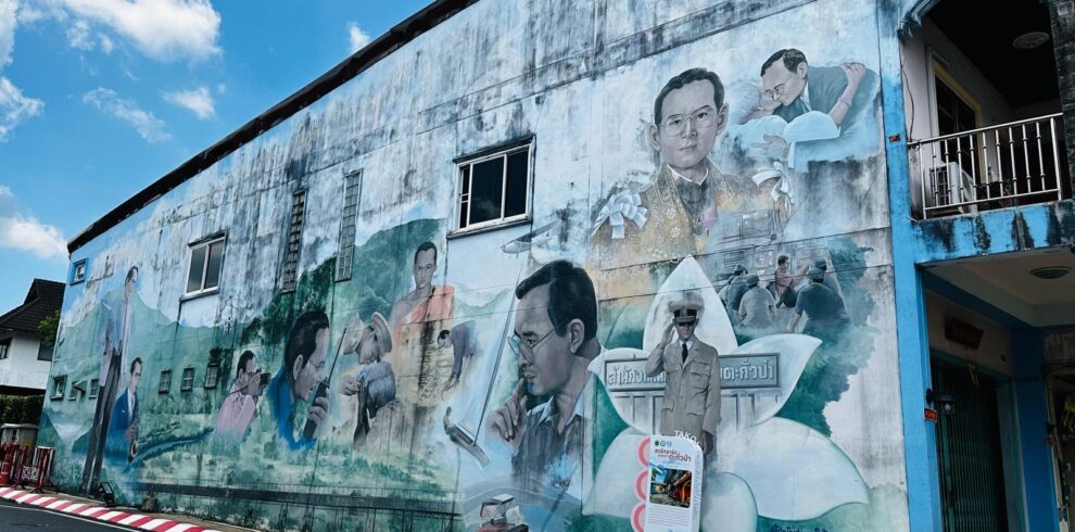 A colorful and detailed hand-painted wall mural depicting local culture on a street in Songkhla Old Town.