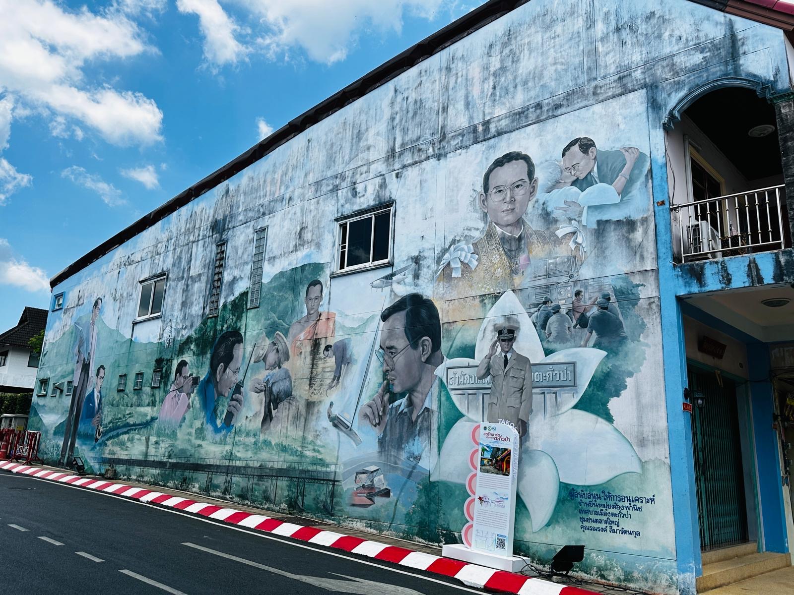 A colorful and detailed hand-painted wall mural depicting local culture on a street in Songkhla Old Town.
