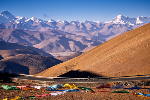 Winding high-altitude mountain roads and snow-capped Himalayan peaks, representing the ultimate test on our Epic Tibet road cycling tour.