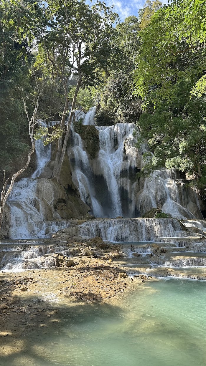 The multi-tiered Kuang Si Waterfall with crystal clear turquoise pools in Luang Prabang, a highlight on our Laos cycling tour.