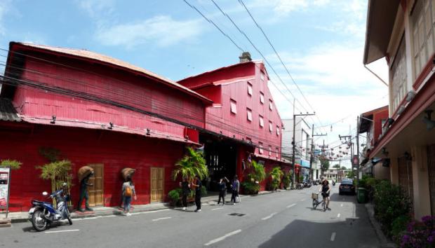 A clean street view of the historic red building in Songkhla Old Town, a unique cultural stop on our Southern Thailand cycling tours.