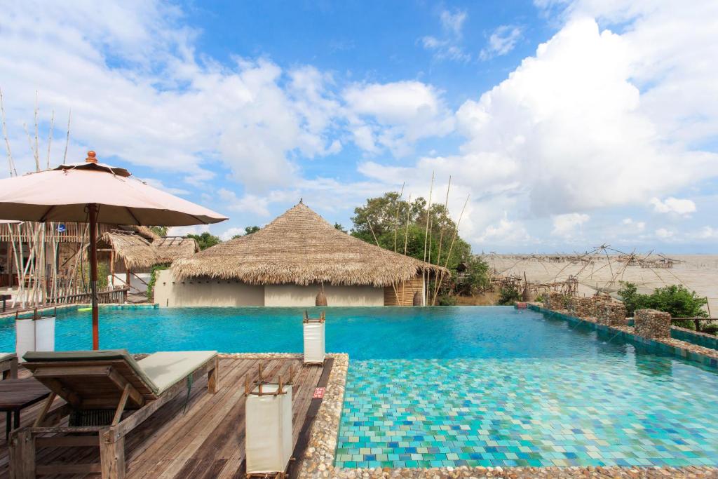 The gorgeous beachfront swimming pool and thatched lounge structures at Sri Pakpra Boutique Resort in Patthalung.