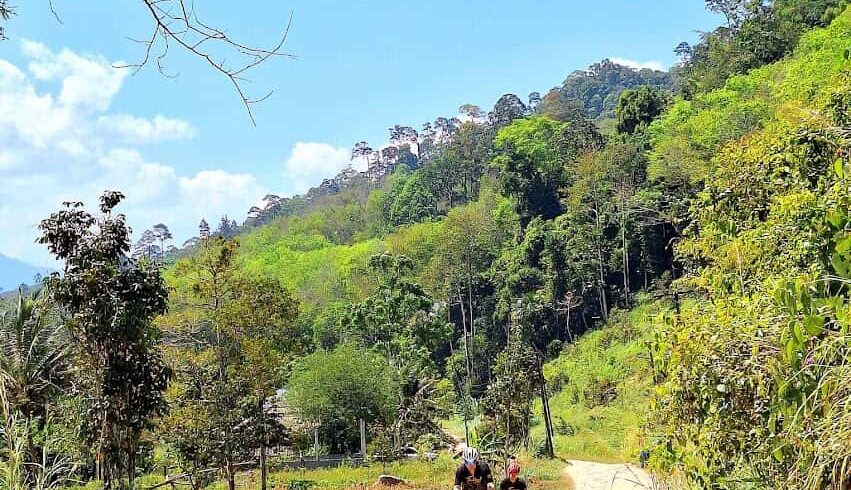 Cyclists riding on an unpaved gravel trail during the Explore South Thailand Road Bike Tour.