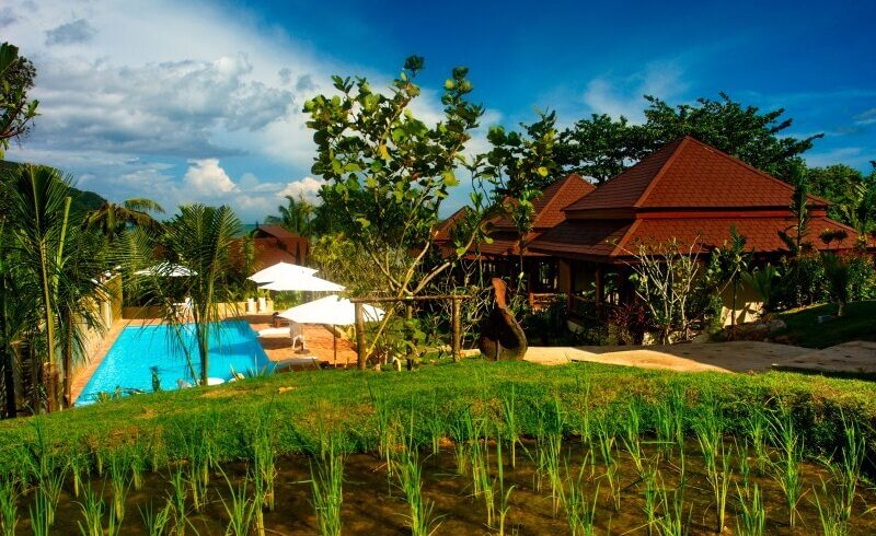 The swimming pool and beautiful wooden villas at Baan Taranya Resort on Koh Yao Yai Island, a featured stop on our Southern Thailand cycling holidays.