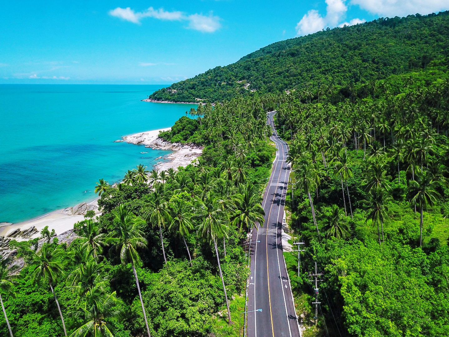 Scenic coastal road between Khanom and Sichon, one of the best cycling routes in Thailand, featuring turquoise sea views, palm forests, and quiet roads along the Gulf of Thailand.