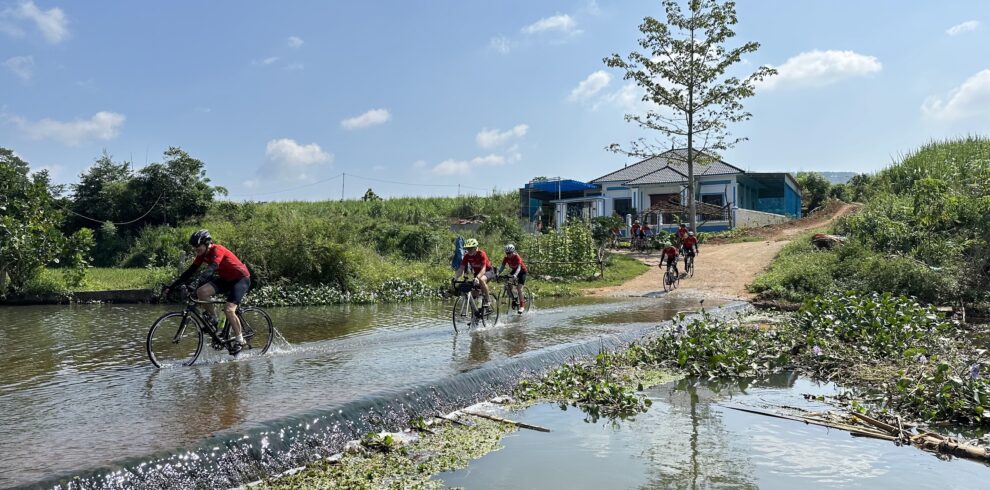 Thailand Cycle Tours guests crossing a river in northern Vietnam on the Bangkok to Hanoi road cycling tour through Vietnam and Laos.