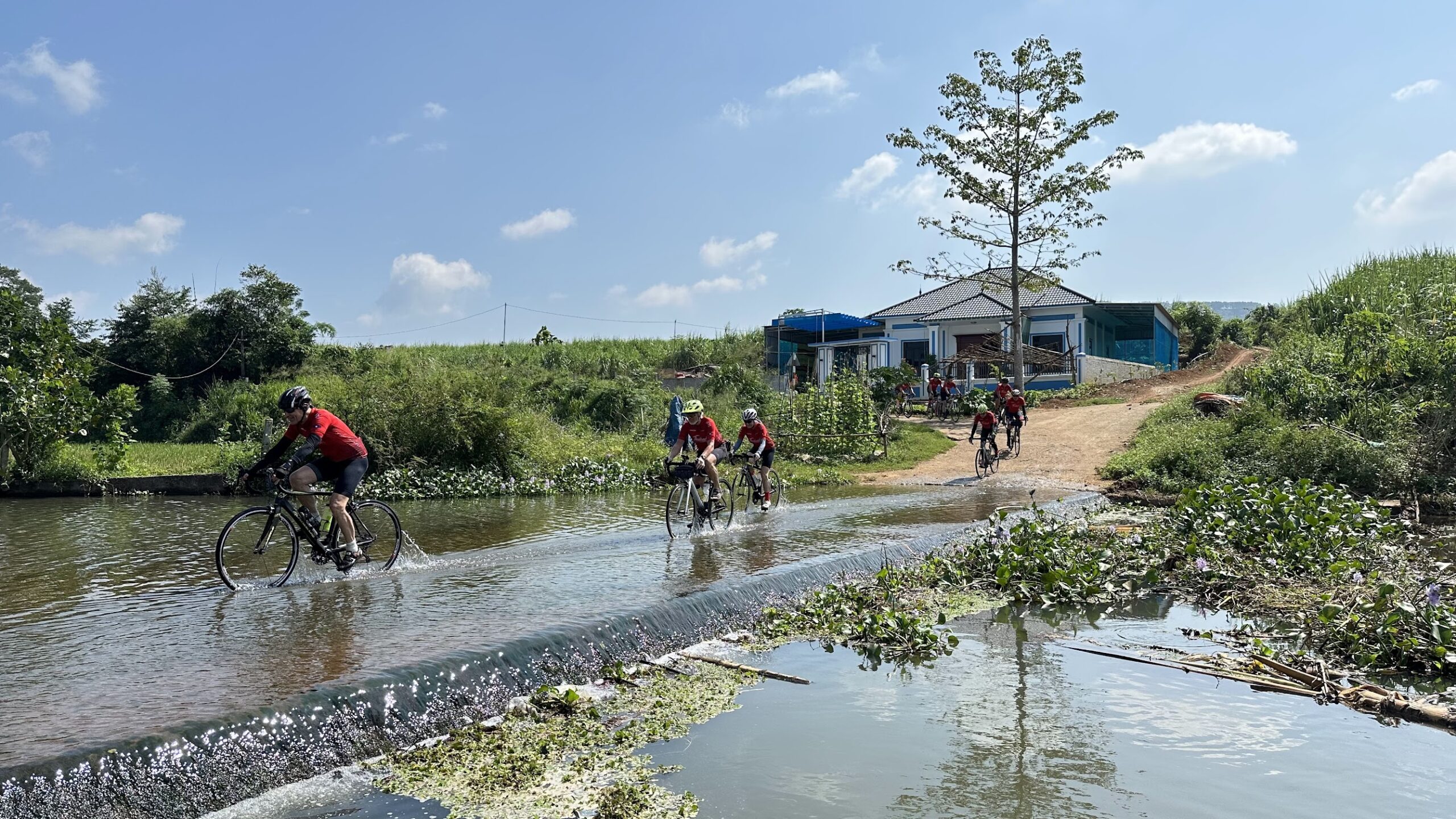 Thailand Cycle Tours guests crossing a river in northern Vietnam on the Bangkok to Hanoi road cycling tour through Vietnam and Laos.